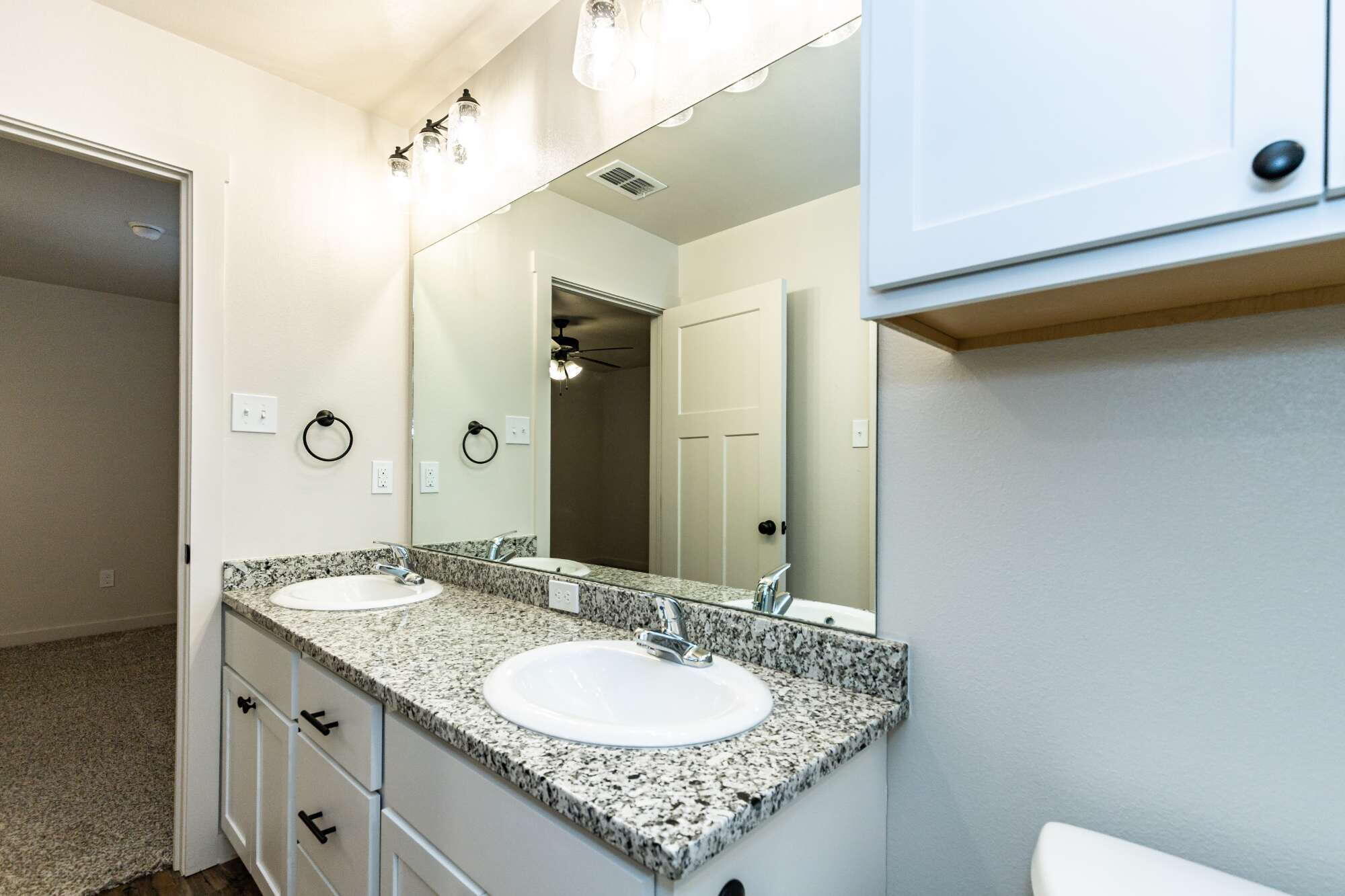 2526 138th Street Lubbock, TX 79423 - Photo 28 of 36 a bathroom with a granite countertop sink and a mirror