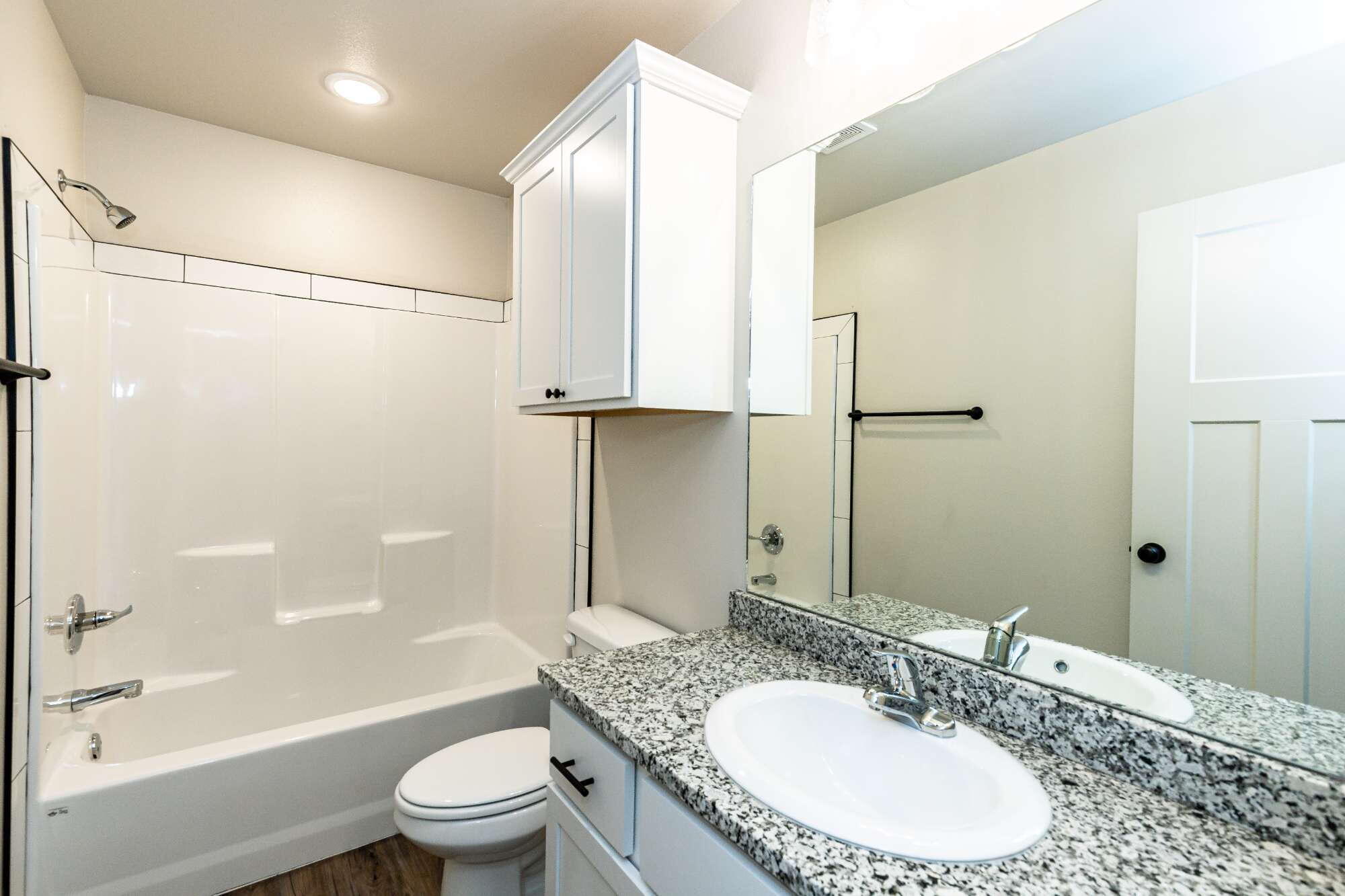 2526 138th Street Lubbock, TX 79423 - Photo 31 of 36 a bathroom with a granite countertop sink toilet and shower