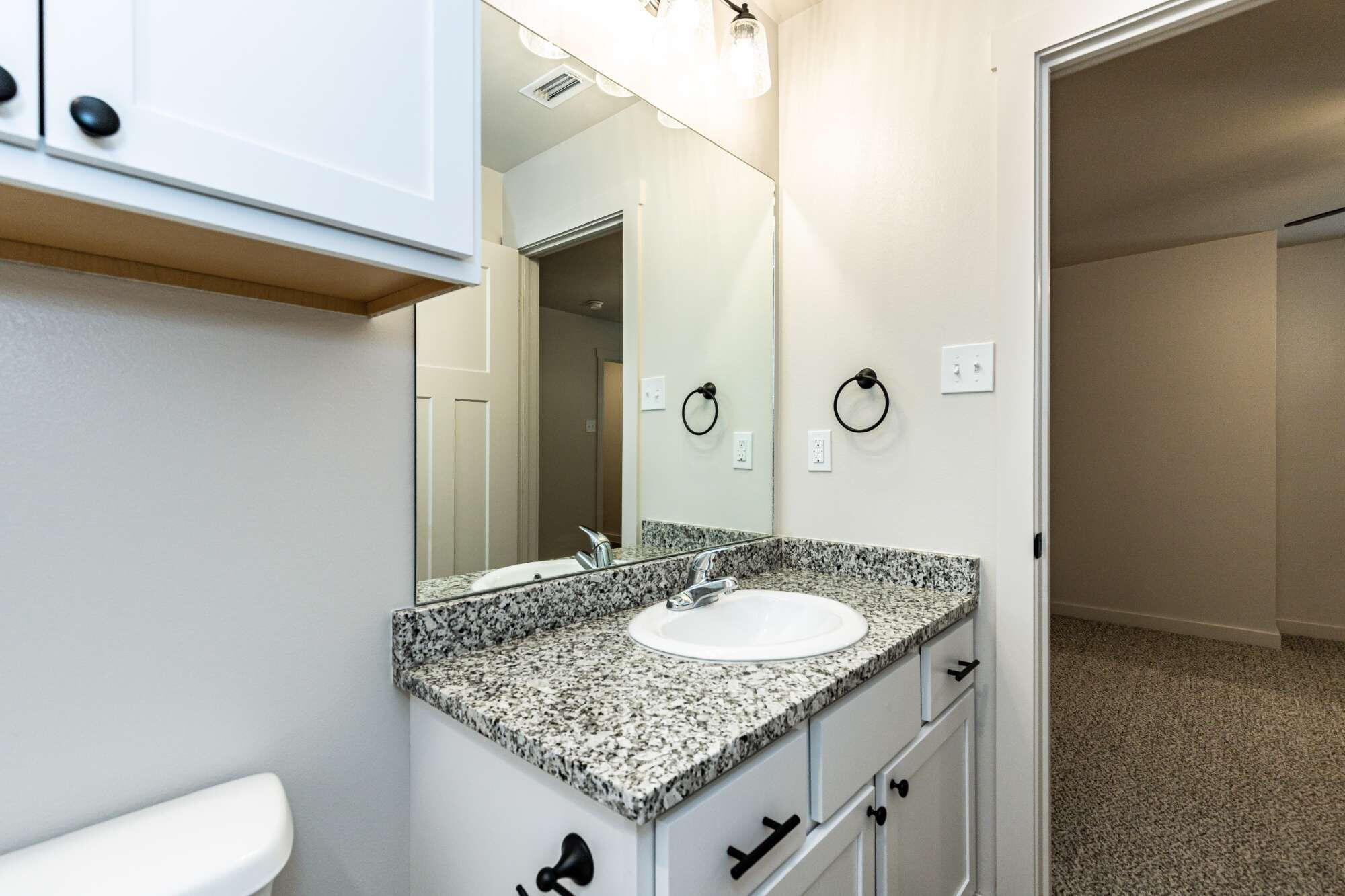 2526 138th Street Lubbock, TX 79423 - Photo 33 of 36 a bathroom with a granite countertop sink and a mirror