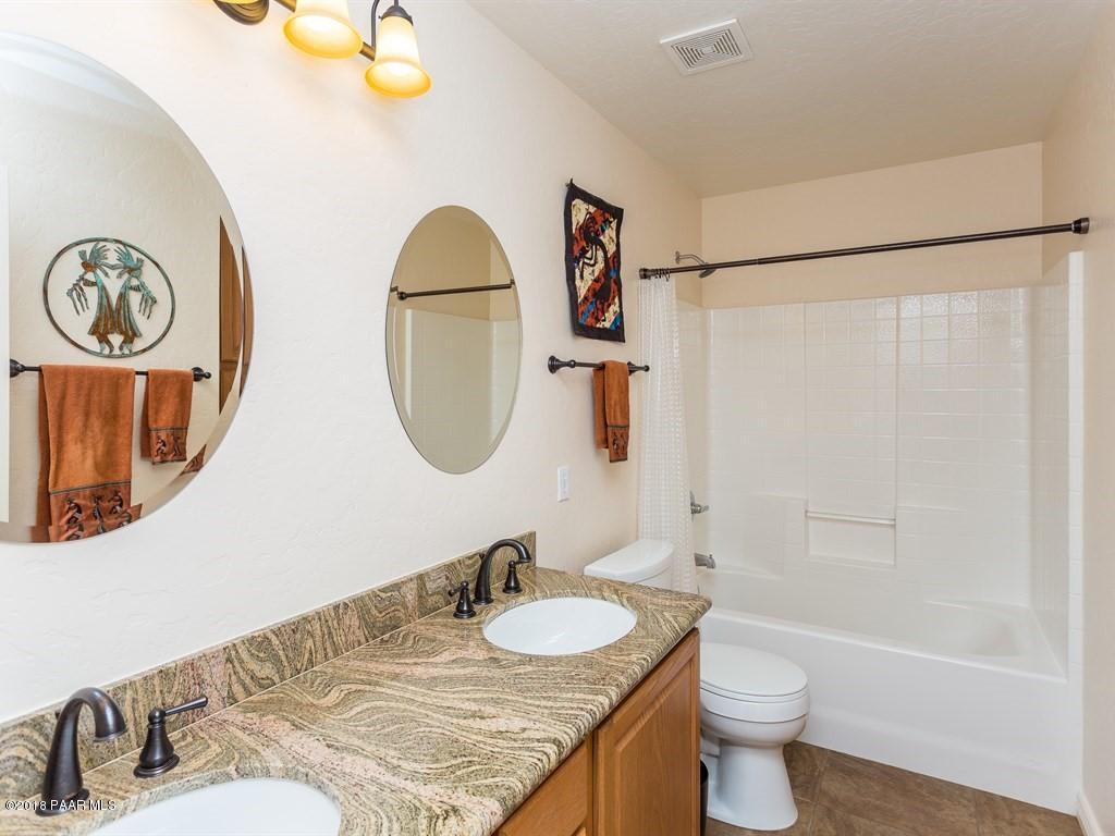 7969 North Sunset Ridge Prescott Valley, AZ 86315 - Photo 13 of 19 a bathroom with a granite countertop sink and a mirror