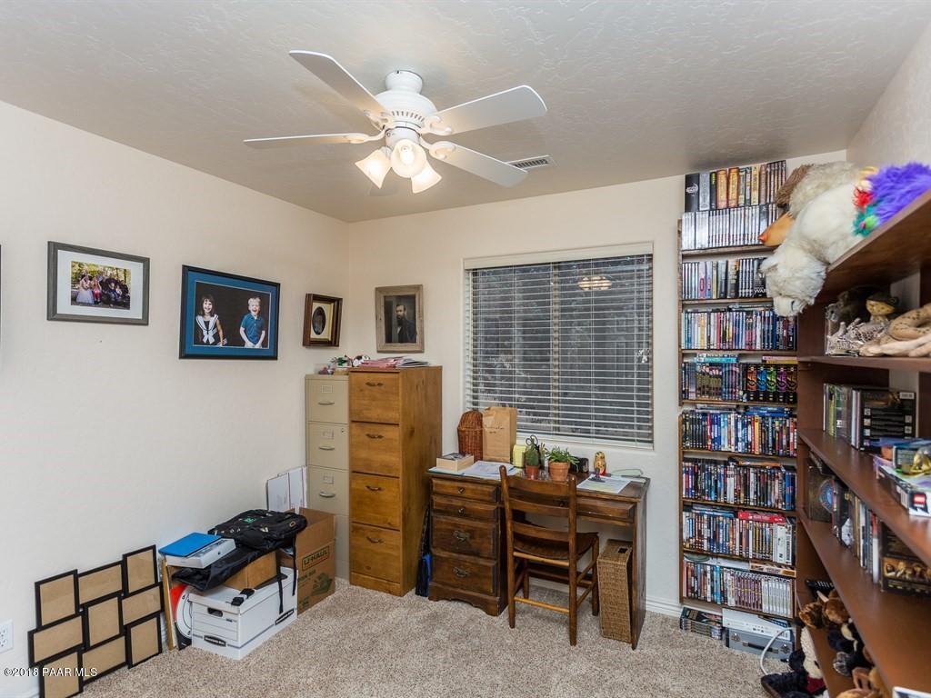7969 North Sunset Ridge Prescott Valley, AZ 86315 - Photo 15 of 19 a view of a workspace with furniture and a book shelf