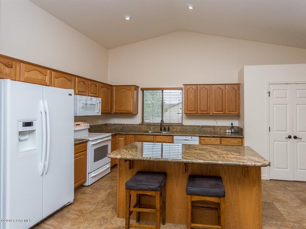 7969 North Sunset Ridge Prescott Valley, AZ 86315 - Photo 5 of 19 a kitchen with granite countertop a stove top oven a sink dishwasher and a refrigerator with wooden floor