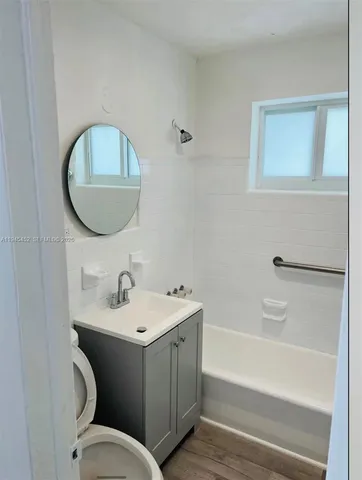 a bathroom with a toilet a sink and mirror
