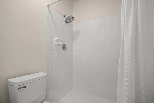 a bathroom with a toilet and a shower