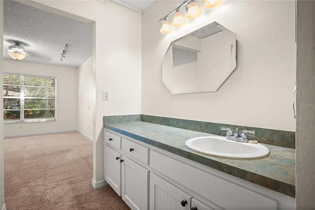 a bathroom with a granite countertop sink a mirror and a bathtub