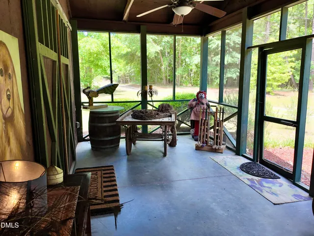 a view of a wooden house with a small yard and large trees