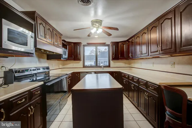 a kitchen with stainless steel appliances granite countertop wooden cabinets a stove top oven a sink and dishwasher