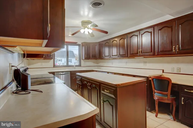a kitchen with a stove a refrigerator and chairs