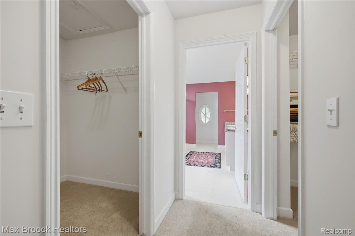1731 Rico Road Commerce Township, MI 48382 - Photo 23 of 48 Carpeted hallway with white walls and trim, leading to a room with a white door, oval window, and vanity