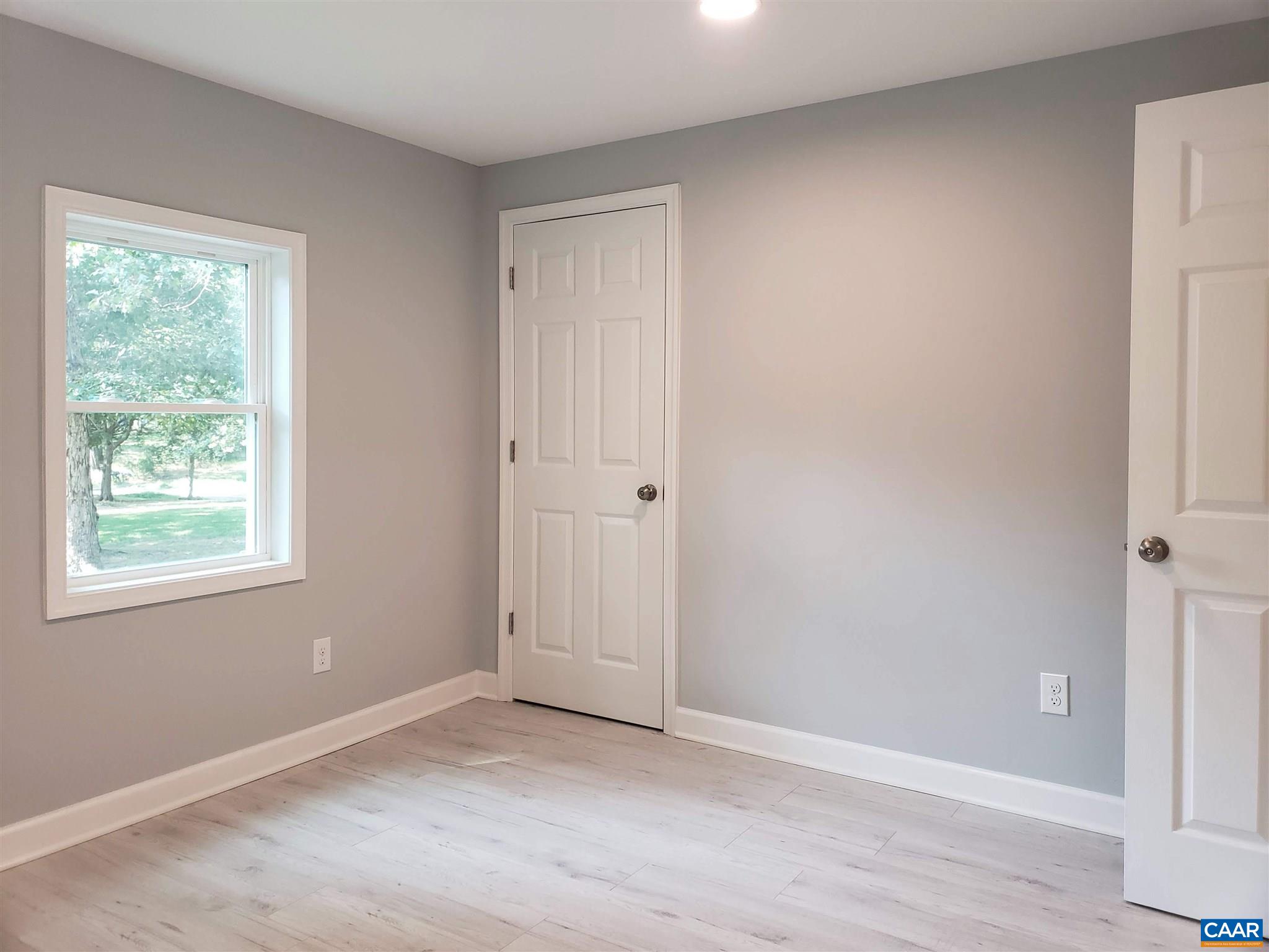 699 Black Cat Road Keswick, VA 22947 - Photo 16 of 33 a view of an empty room with wooden floor and a window