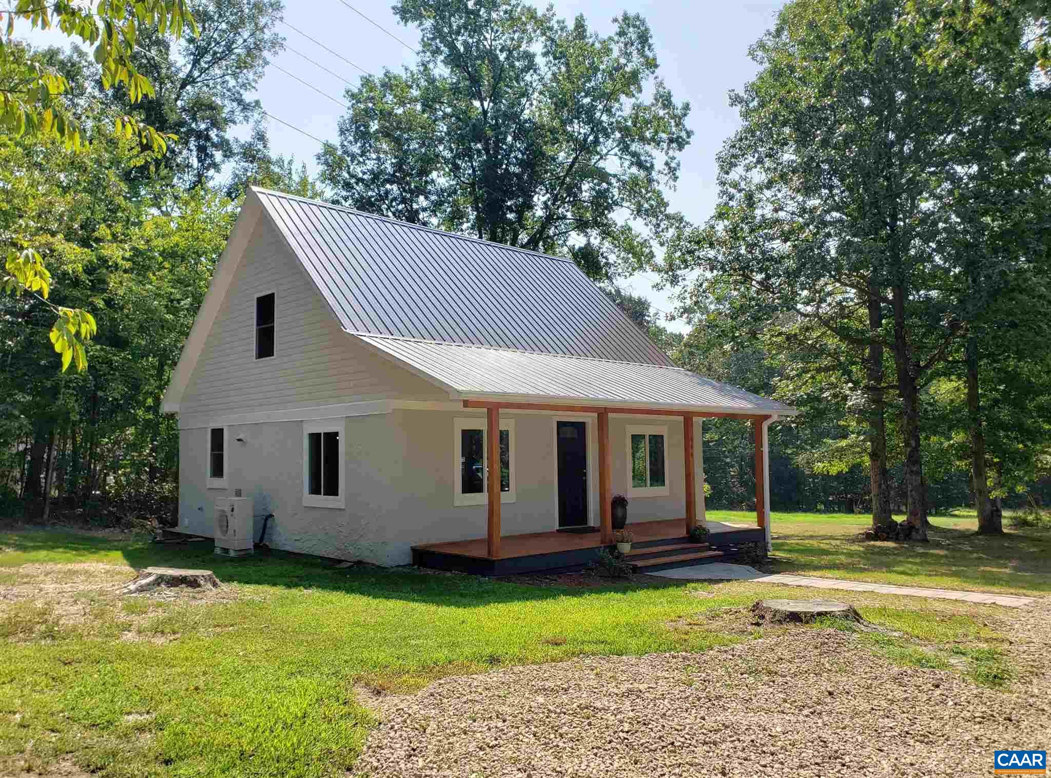 699 Black Cat Road Keswick, VA 22947 - Photo 30 of 33 a view of a white house with a big yard plants and large trees