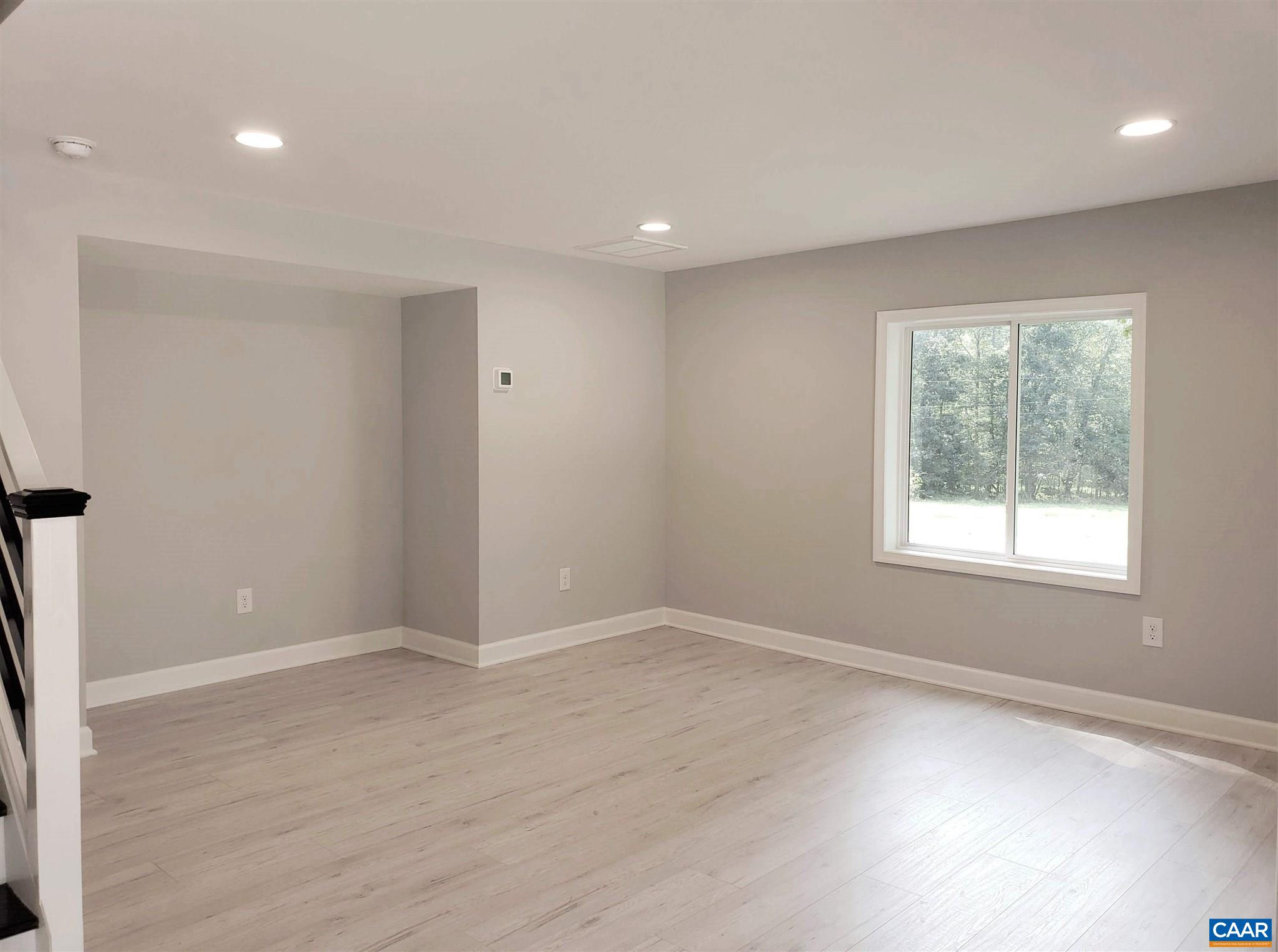 699 Black Cat Road Keswick, VA 22947 - Photo 4 of 33 an empty room with wooden floor and windows