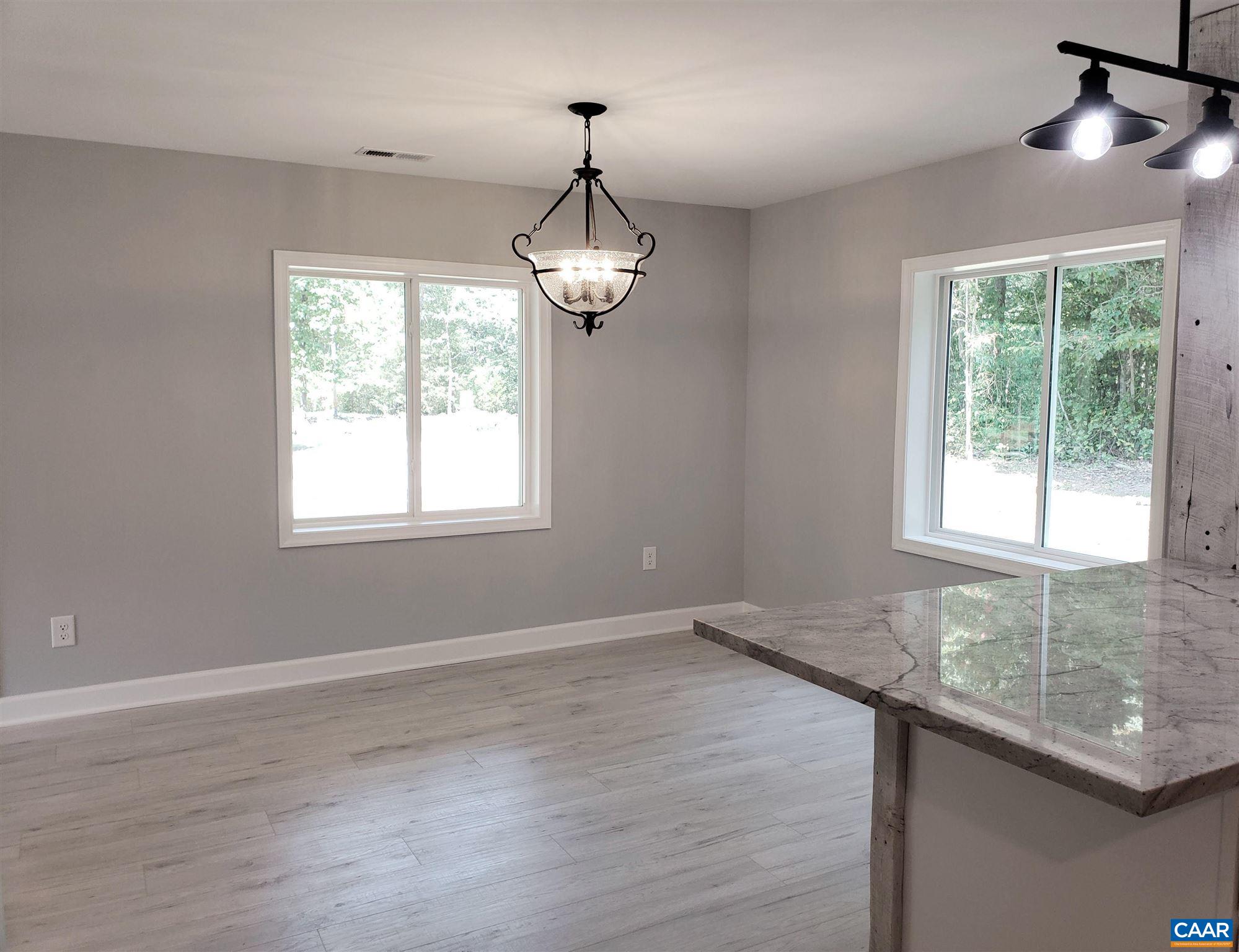 699 Black Cat Road Keswick, VA 22947 - Photo 5 of 33 a view of an empty room with wooden floor and a window