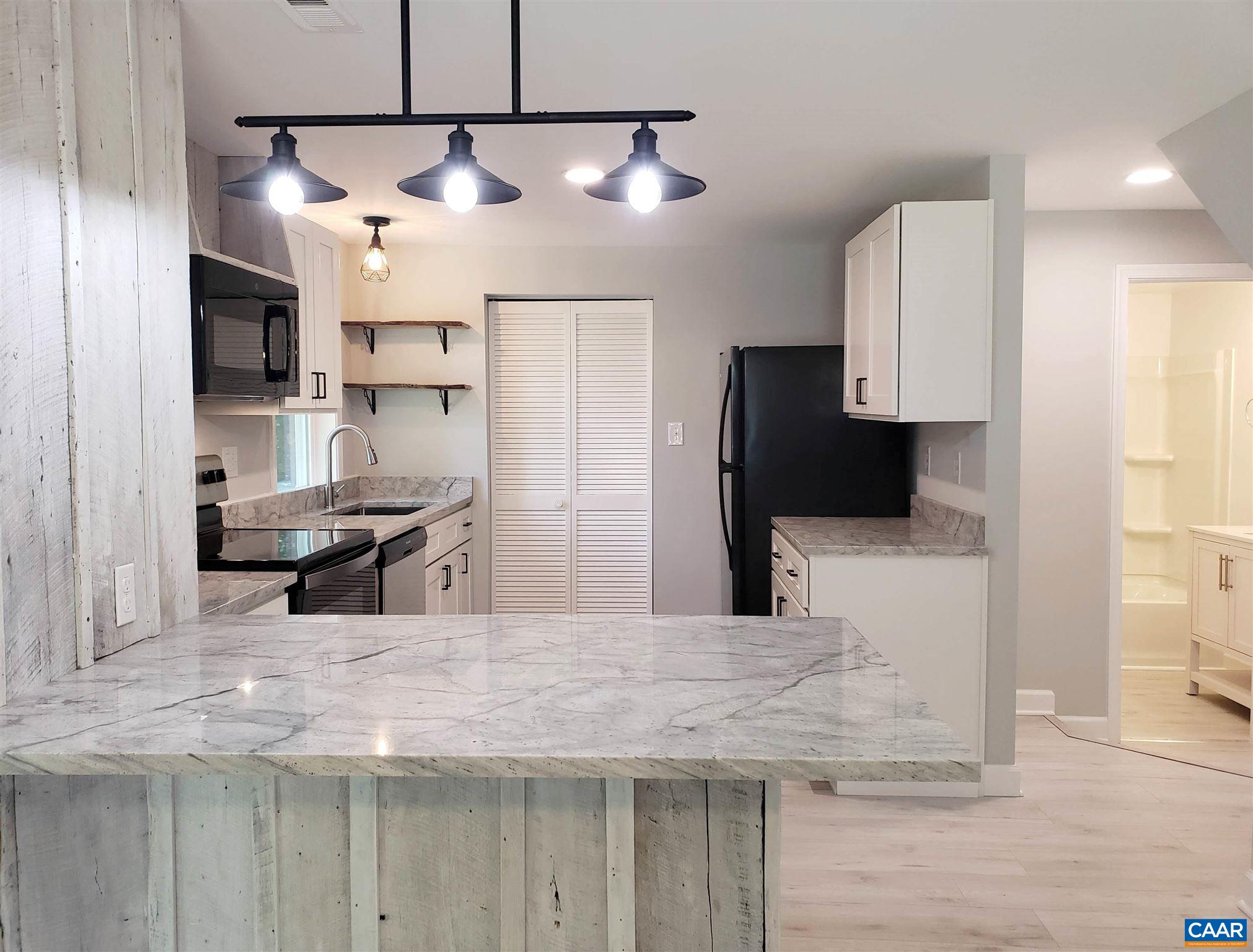 699 Black Cat Road Keswick, VA 22947 - Photo 8 of 33 a kitchen with stainless steel appliances kitchen island granite countertop a refrigerator and a sink