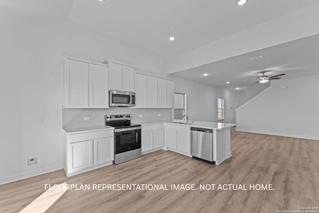 an empty room with wooden floor closet and fan