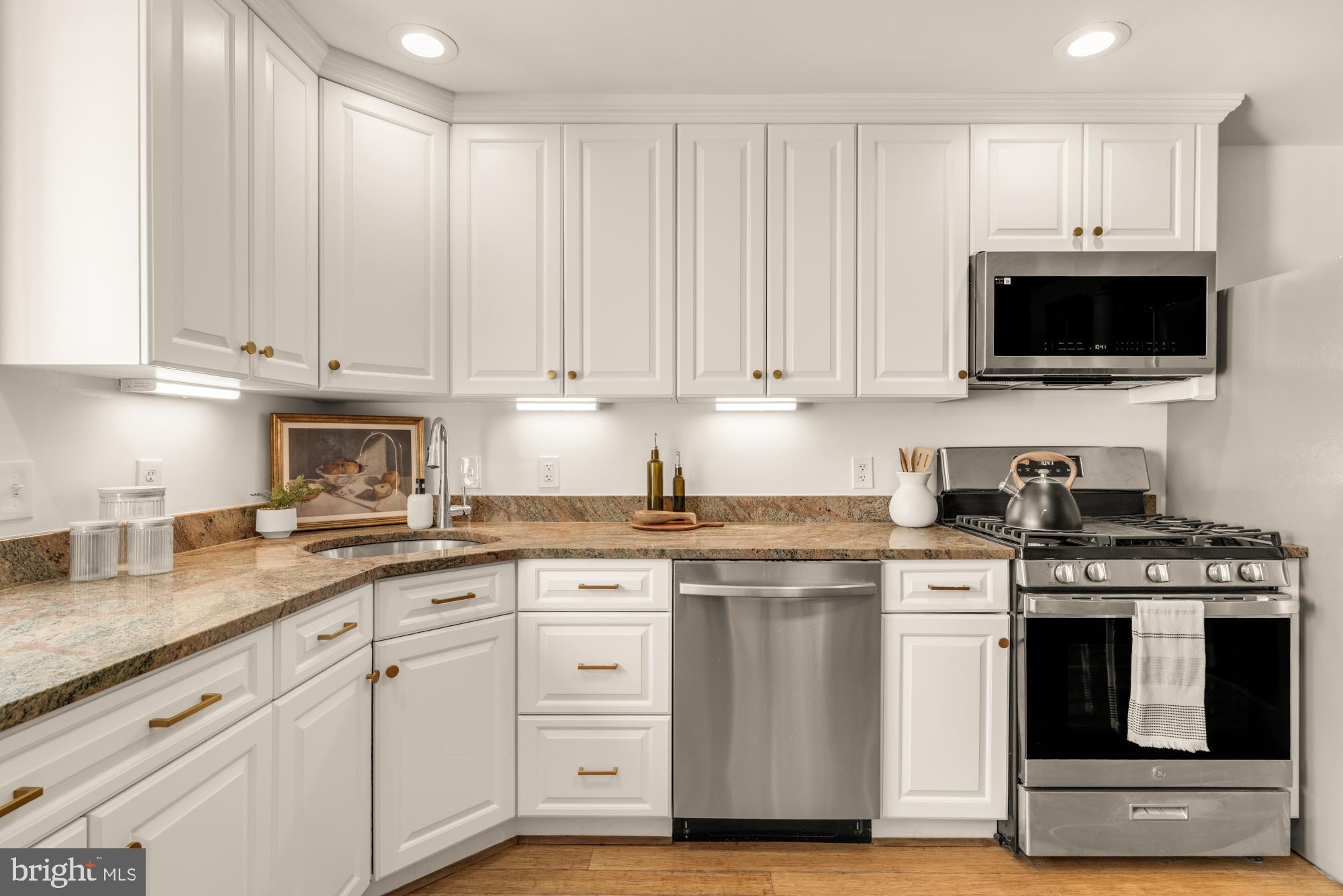 1213 Battery Avenue Baltimore, MD 21230 - Photo 16 of 39 a kitchen with granite countertop white cabinets and stainless steel appliances
