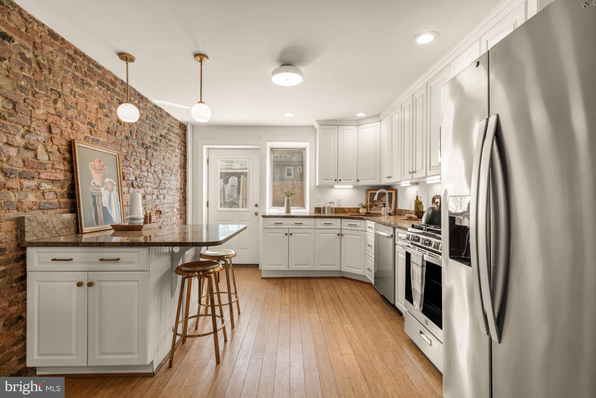1213 Battery Avenue Baltimore, MD 21230 - Photo 17 of 39 a kitchen with stainless steel appliances a refrigerator a sink dishwasher a stove and white cabinets with wooden floor
