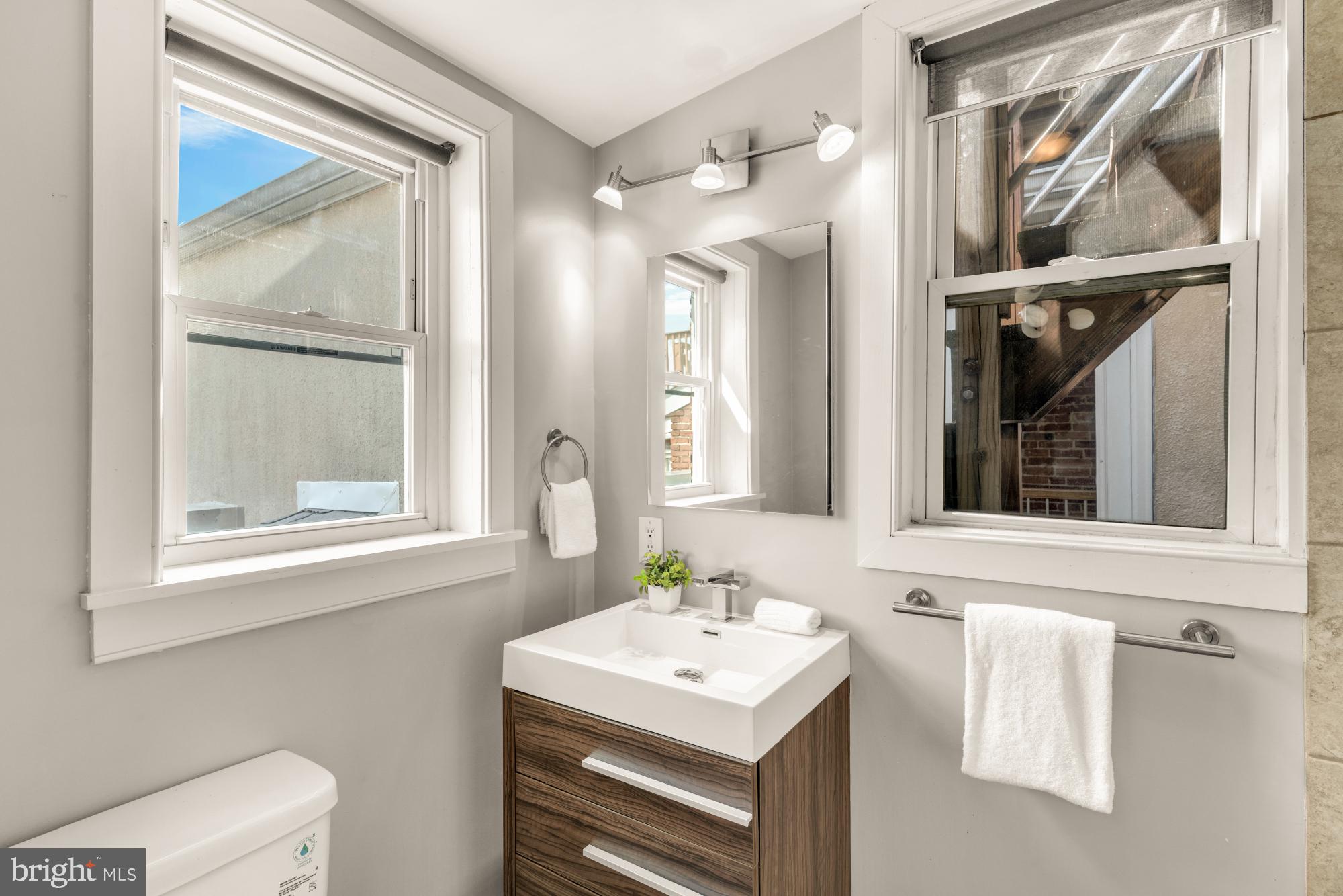 1213 Battery Avenue Baltimore, MD 21230 - Photo 32 of 39 a bathroom with a sink a vanity and a mirror