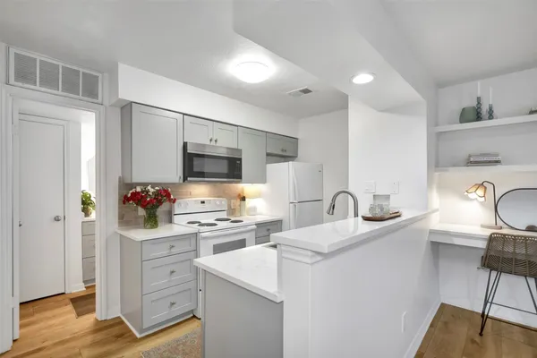 a kitchen with stainless steel appliances granite countertop a sink stove refrigerator and cabinets