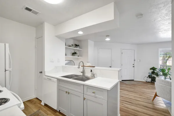 a kitchen with a sink cabinets and wooden floor