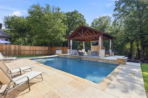 a view of house with swimming pool and sitting area