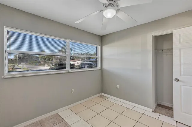 a view of an empty room and chandelier fan