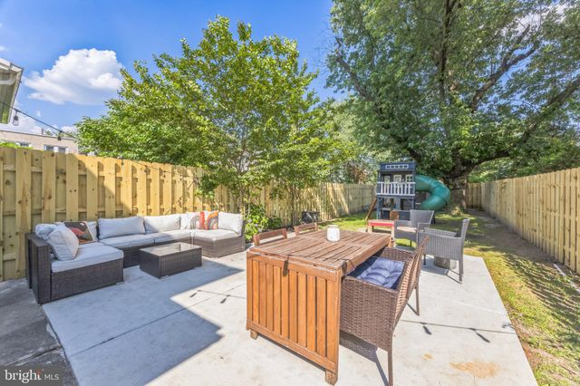 a view of a patio with couches table and chairs and potted plants