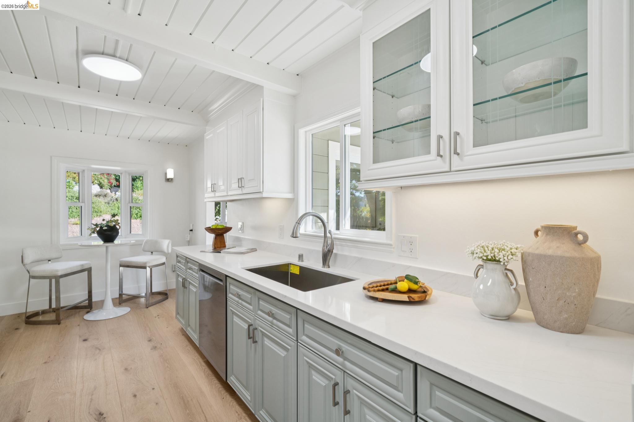 1321 Sunset Loop Lafayette, CA 94549 - Photo 12 of 49 White shaker cabinetry with glass-front uppers, stainless steel appliances, light wood-finish flooring, and white countertops