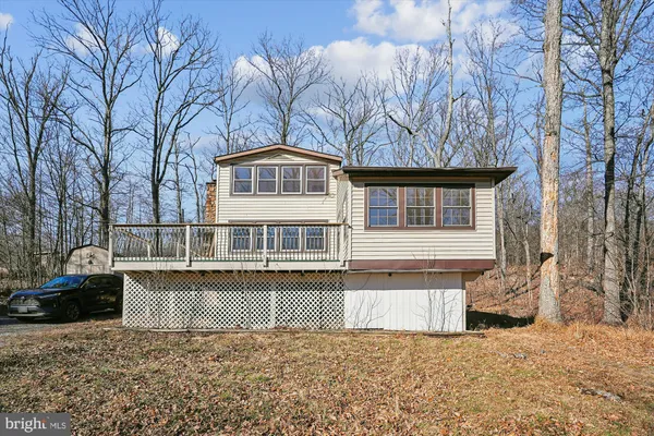 a front view of a house with a yard and trees