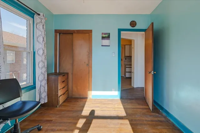 a view of a hallway with wooden floor and furniture