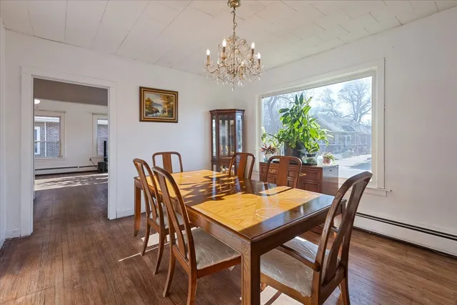 a view of a dining room with furniture a chandelier and wooden floor