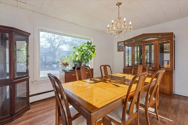 a view of a dining room with furniture a chandelier and wooden floor