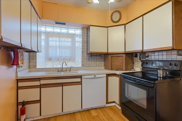 a kitchen with stainless steel appliances a sink cabinets and a wooden floor