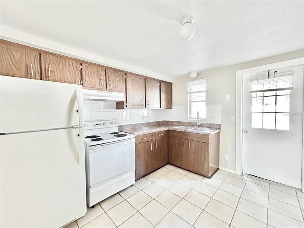 5805 Delaware Avenue New Port Richey, FL 34652 - Photo 5 of 12 a kitchen with a refrigerator sink and cabinets