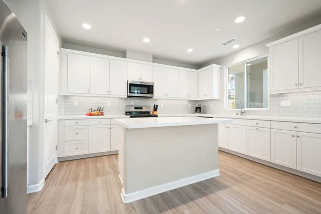 a kitchen with white cabinets and white appliances