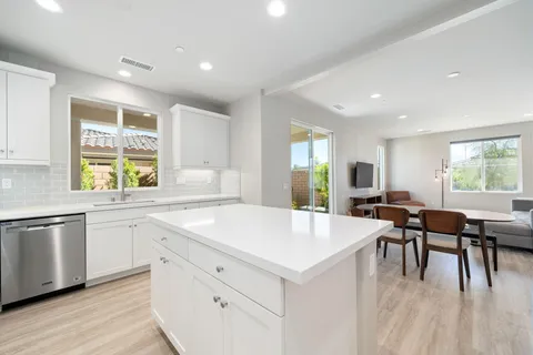 a large kitchen with kitchen island a sink table and chairs