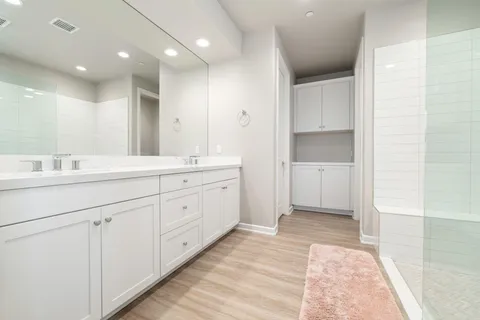 a spacious bathroom with a sink a mirror and a shower