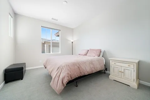 a spacious bedroom with a bed and a tv