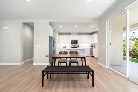 a view of kitchen with wooden floor and chairs