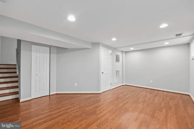 a view of an empty room with wooden floor