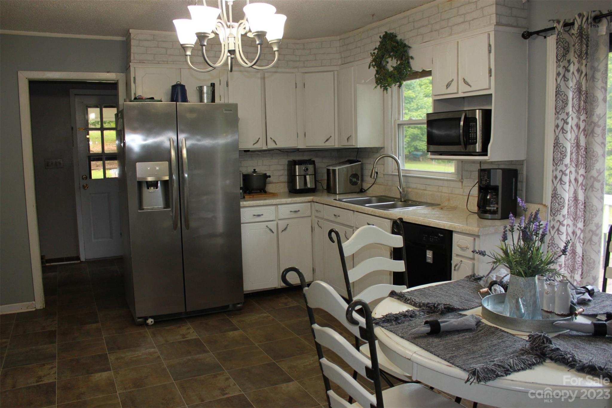 901 Coopers Gap Road Rutherfordton, NC 28139 - Photo 11 of 47 a kitchen with stainless steel appliances granite countertop a refrigerator a stove a sink dishwasher and white cabinets with wooden floor