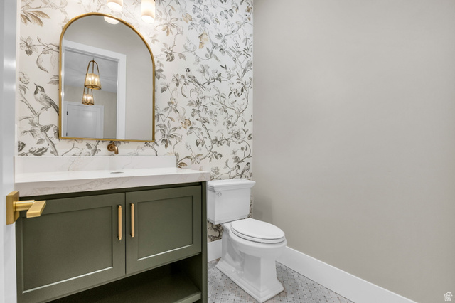 2828 Jojo Road Eagle Mountain, UT 84005 - Photo 21 of 63 Powder room featuring a sage green vanity with gold hardware, a white countertop, and an arched gold-framed mirror