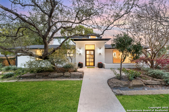 a front view of a house with a yard and tree s