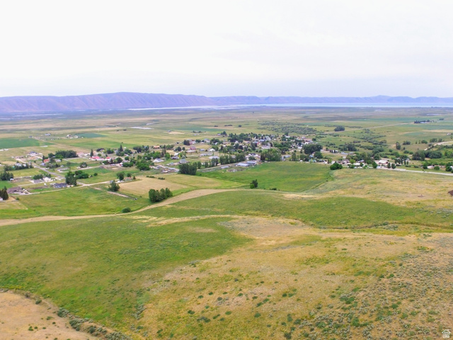 Expansive rural landscape featuring rolling hills and distant water