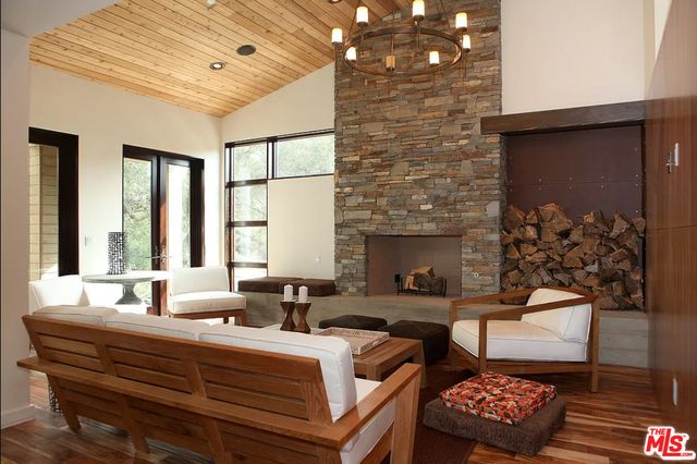 a living room with fireplace furniture and a potted plant