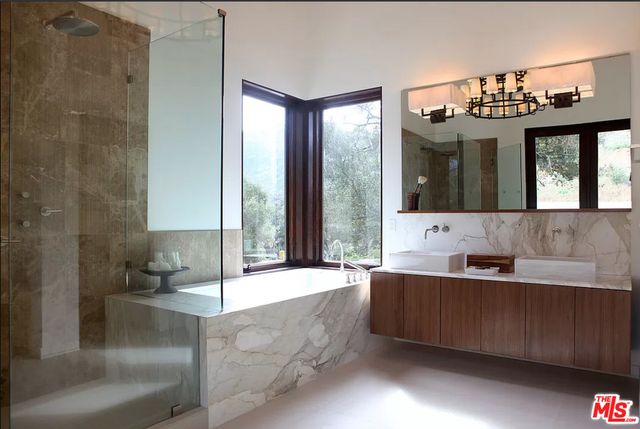 a bathroom with a bathtub sink and mirror