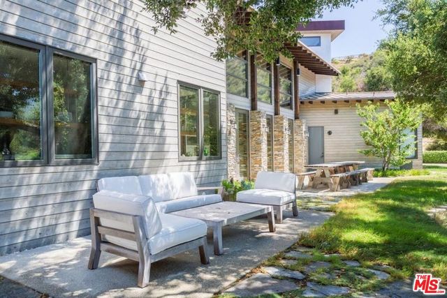 a view of a patio with couches table and chairs and potted plants