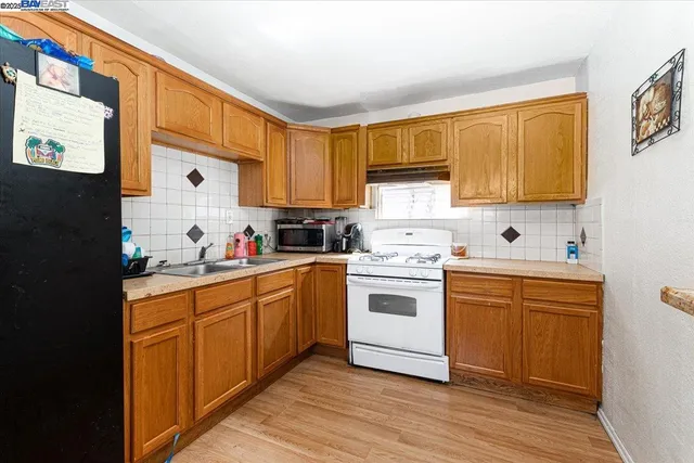 a kitchen with granite countertop a sink cabinets stainless steel appliances and a window