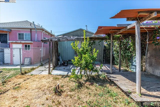 a backyard of a house with table and chairs under an umbrella