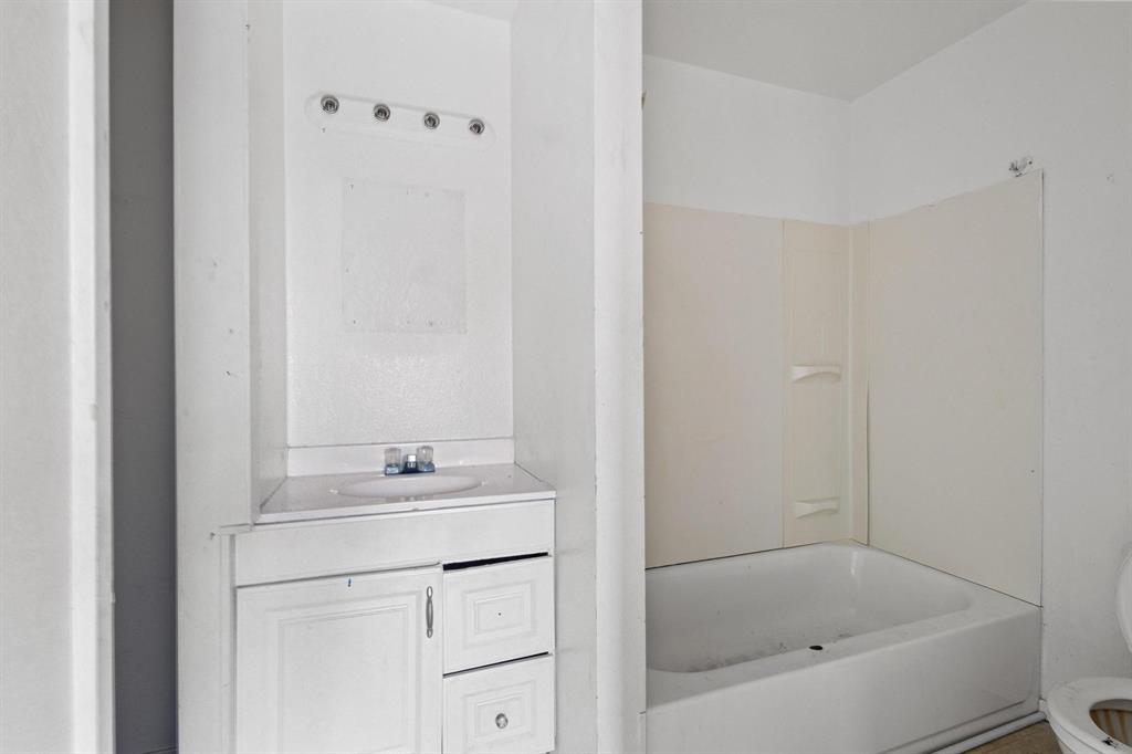 646 South Main Street Paris, TX 75460 - Photo 13 of 39 a bathroom with a bathtub sink vanity and mirror